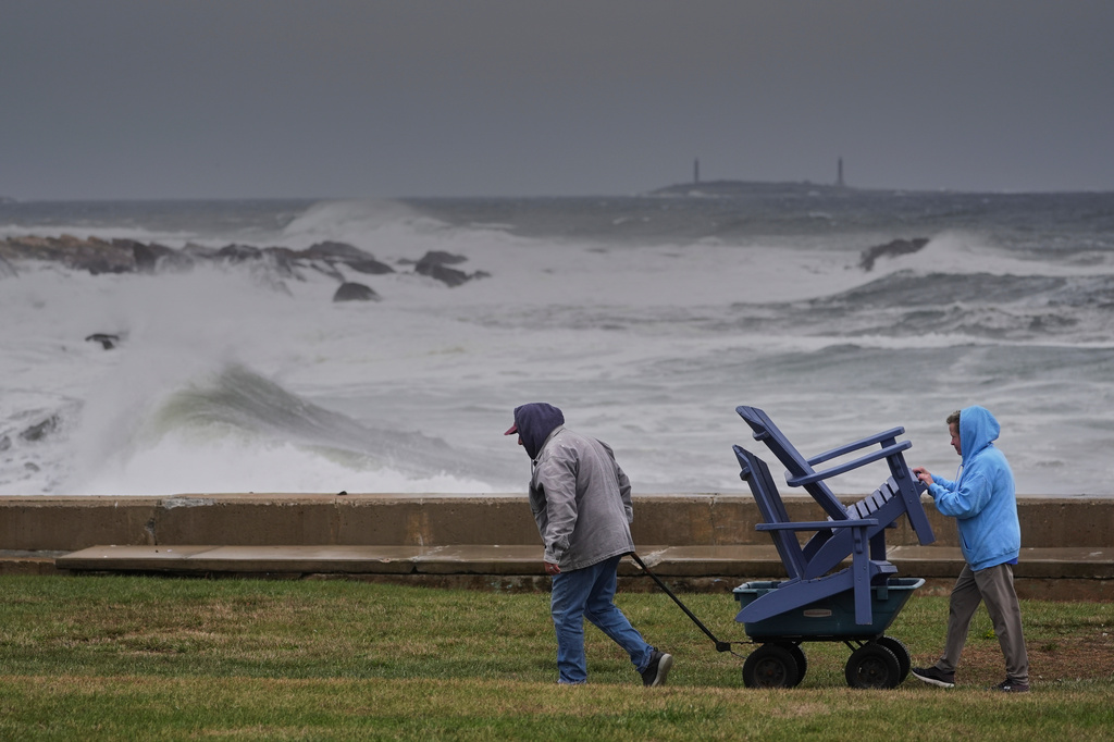 Chuck and Teresa Palmieri move lawn furniture to a safe location at a relative's seaside property as the Atlantic Ocean kicks up surf during the early stages of a nor'easter storm, Friday, Sept. 25, 2026, in Gloucester, Mass. (AP Photo/Robert F. Bukaty)