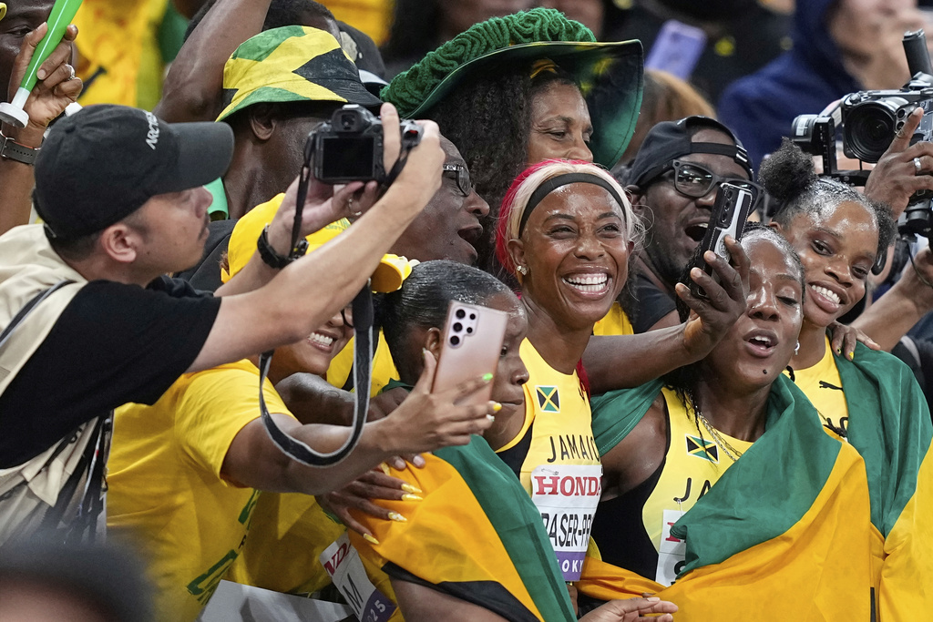 Jamaica's Shelly-Ann Fraser-Pryce and her teammates celebrate with supporters after taking the silver in the women's 4 X 100 meters relay final at the World Athletics Championships in Tokyo, Sunday, Sept. 21, 2025. (AP Photo/Petr David Josek)