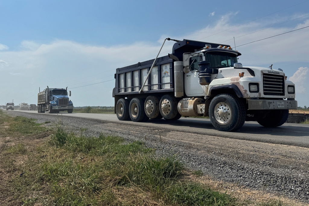 Trucks pass by the site of Meta's Richland Parish Data Center in Holly Ridge, La., Monday, Aug. 18, 2025. (AP Photo/Sophie Bates)