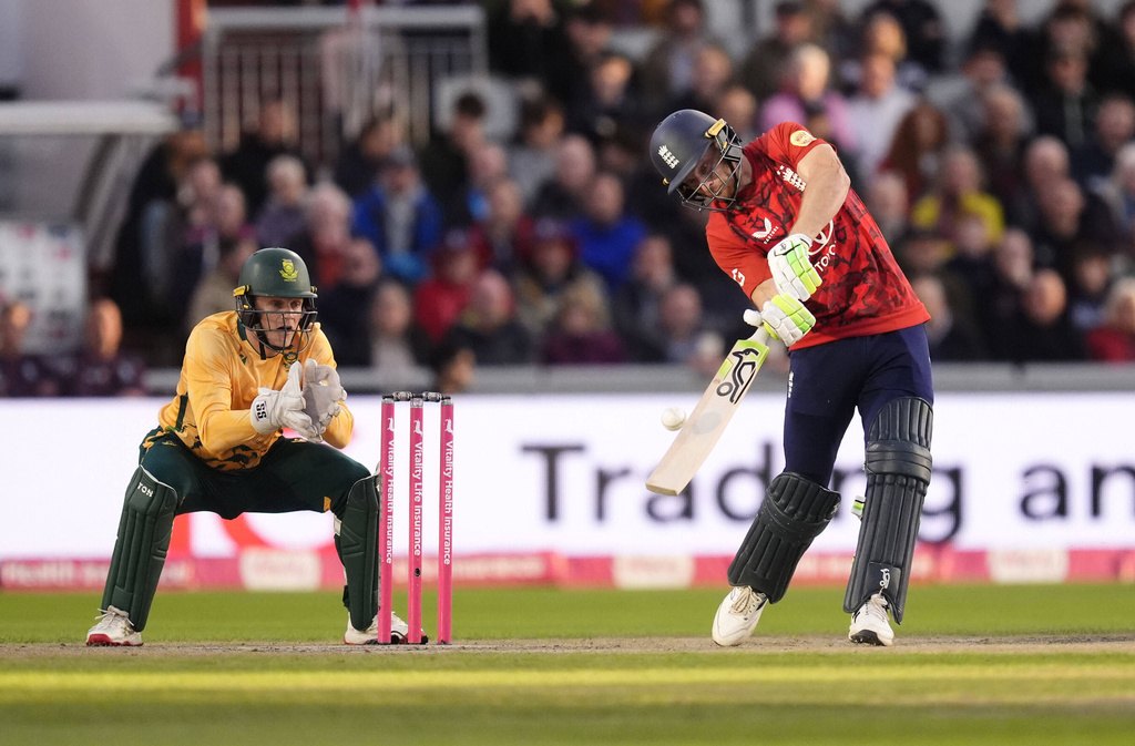 England's Jos Buttler, right, strikes the ball for four runs against South Africa during the second International T20 Match at Emirates Old Trafford in Manchester, England, Friday, Sept. 12, 2025. (Nick Potts/PA via AP)