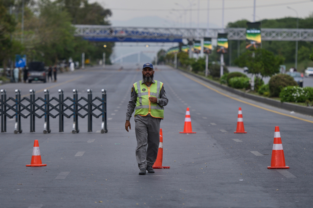 A police officer stands to divert traffic on a road barricaded by authorities due to security arrangements for possible second round of talks between the U.S. and Iran, in Islamabad, Pakistan, Friday, April 24, 2026. (AP Photo/M.A. Sheikh)