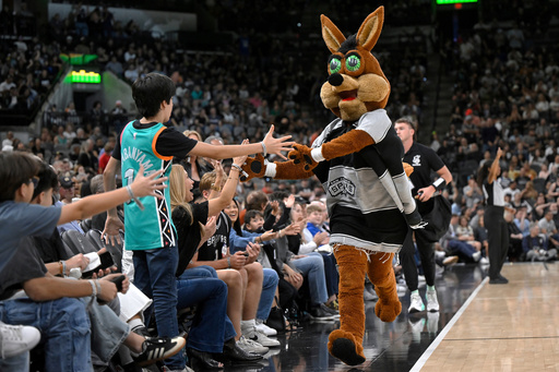 FILE - The Coyote, right, San Antonio Spurs' mascot, greets fans during the second half of an NBA basketball game against the Minnesota Timberwolves, Saturday, Nov. 2, 2024, in San Antonio. San Antonio won 113-103. (AP Photo/Darren Abate, File) FILE - The Coyote, right, San Antonio Spurs' mascot, greets fans during the second half of an NBA basketball game against the Minnesota Timberwolves, Saturday, Nov. 2, 2024, in San Antonio. San Antonio won 113-103. (AP Photo/Darren Abate, File)