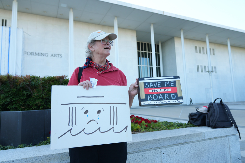 Laura Bligh holds a sign outside the John F. Kennedy Center for the Performing Arts in Washington, Tuesday, Sept. 15, 2026. (AP Photo/Jacquelyn Martin)