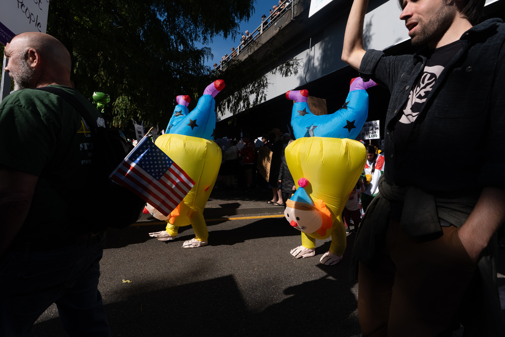 People in clown costumes participate in a "No Kings" protest march in Portland, Ore., on Saturday, Oct. 18, 2025. (AP Photo/Jenny Kane)