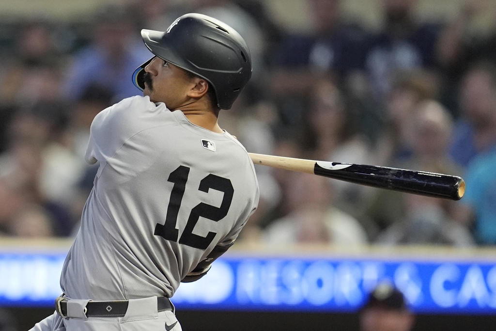New York Yankees' Trent Grisham (12) hits an RBI-single against the Minnesota Twins in the third inning of a baseball game, Tuesday, Sept. 16, 2025, in Minneapolis. (AP Photo/Mike Stewart)