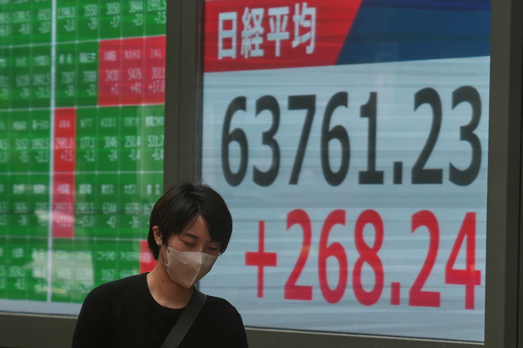A person walks in front of an electronic stock board showing Japan's Nikkei index at a securities firm Tuesday, Sept. 15, 2026, in Tokyo. (AP Photo/Eugene Hoshiko)