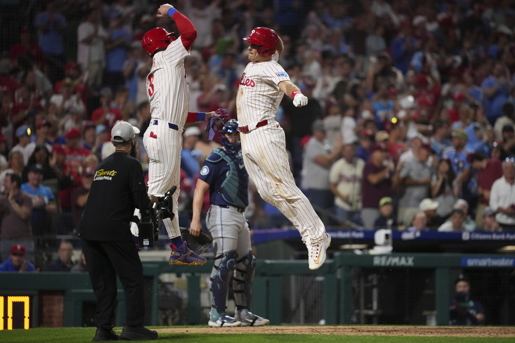 Philadelphia Phillies' J.T. Realmuto, right, and Bryce Harper celebrate after Realmuto's two-run home run against Seattle Mariners pitcher Matt Brash during the eighth inning of a baseball game Tuesday, Aug. 19, 2025, in Philadelphia. (AP Photo/Matt Slocum)