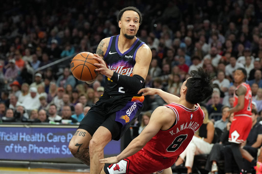 Phoenix Suns guard Amir Coffey gets fouled by Chicago Bulls guard Yuki Kawamura (8) during the first half of an NBA basketball game, Thursday, March 5, 2026, in Phoenix. (AP Photo/Rick Scuteri)