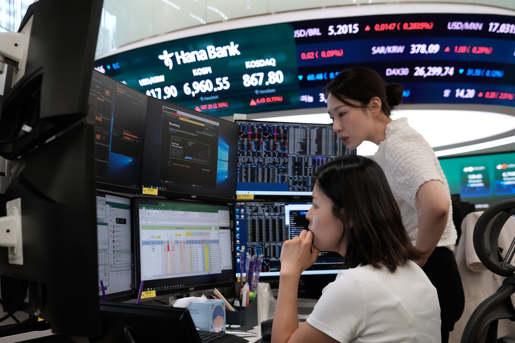 Currency traders work at the foreign exchange dealing room of the Hana Bank headquarters in Seoul, South Korea, Friday, Aug. 14, 2026. (AP Photo/Ahn Young-joon)