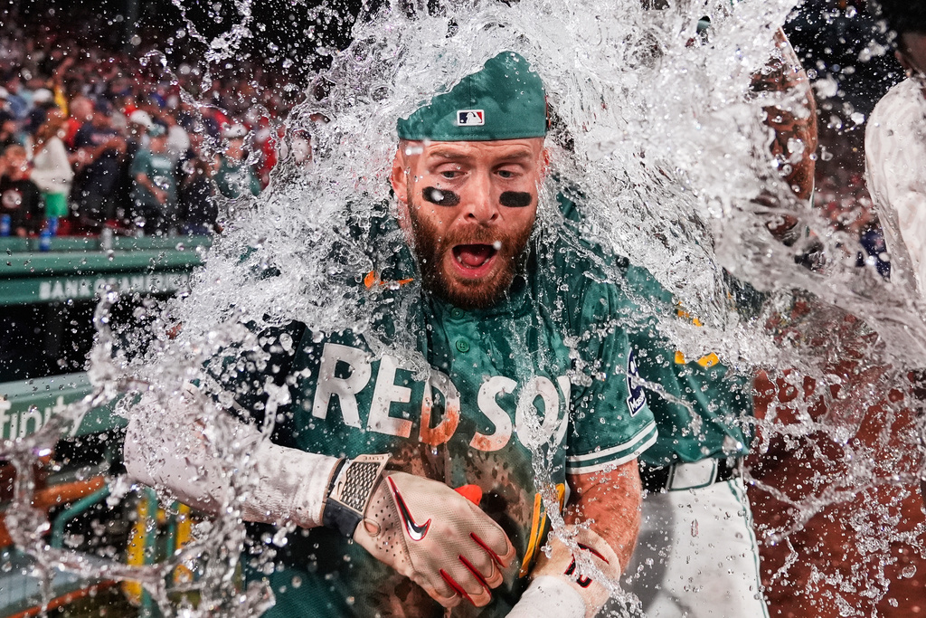 Boston Red Sox's Trevor Story is doused with ice water after his game-winning single in the bottom of the ninth inning of a baseball game against the Miami Marlins at Fenway Park, Friday, Aug. 15, 2025, in Boston. (AP Photo/Charles Krupa)
