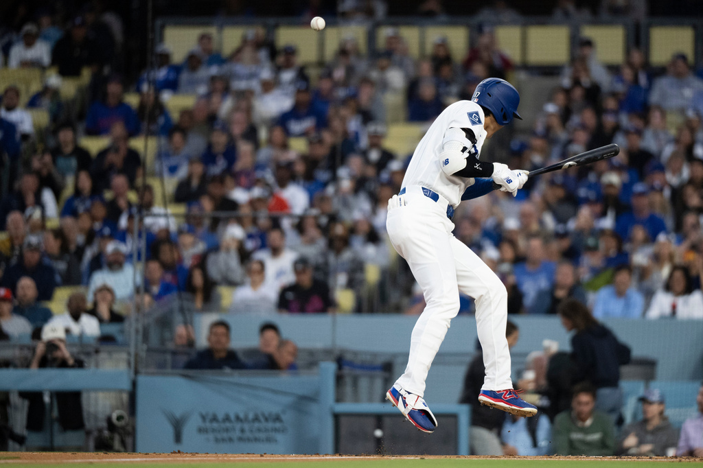Los Angeles Dodgers' Shohei Ohtani takes a hit by pitch during the first inning of a baseball game against the New York Mets in Los Angeles, Monday, April 13, 2026. (AP Photo/Kyusung Gong)