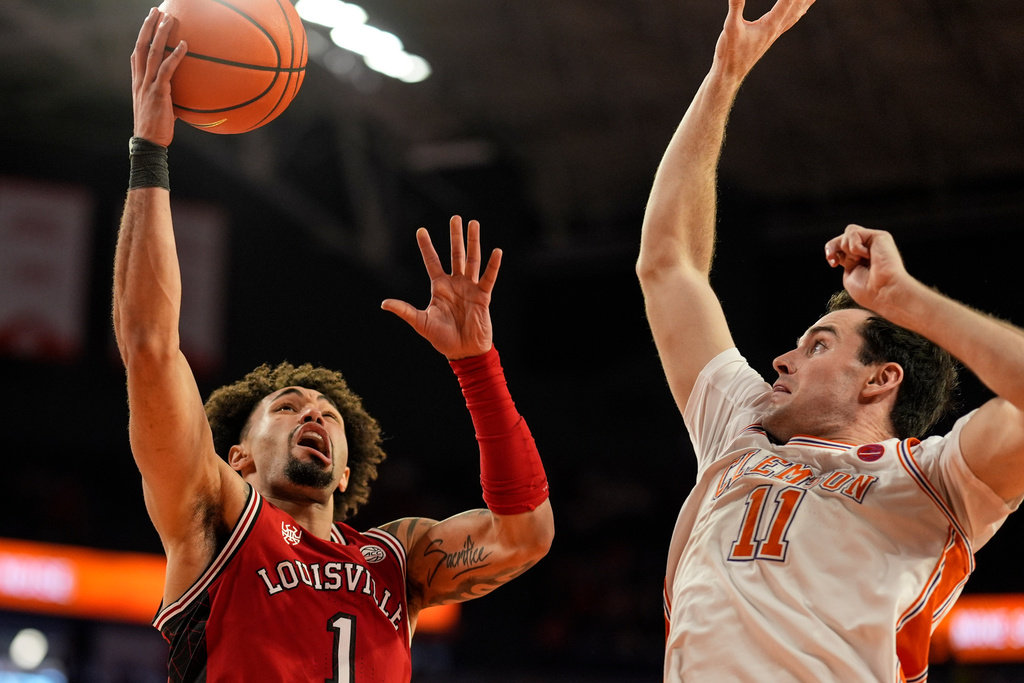 Louisville guard J'vonne Hadley (1) shoots against Clemson forward Nick Davidson (11) during the first half of an NCAA basketball game, Saturday, Feb. 28, 2026, in Clemson, S.C. (AP Photo/Mike Stewart)