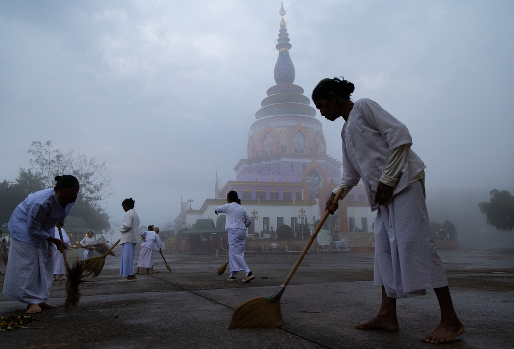 A group of women sweep the grounds of a pagoda in Tha Ton, Thailand, on Feb. 20, 2026. (AP Photo/Anton L. Delgado)