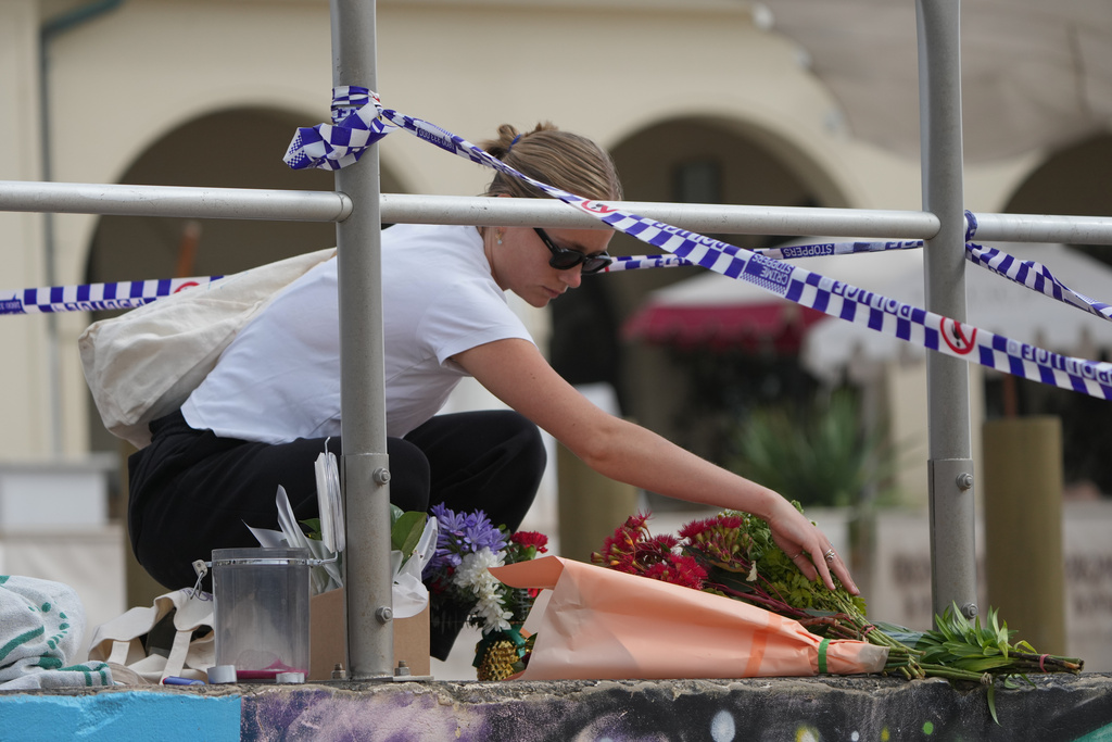 Shenna McClean lays flowers at a memorial at Sydney's Bondi Beach, Monday, Dec. 15, 2025, a day after a shooting. (AP Photo/Mark Baker)
