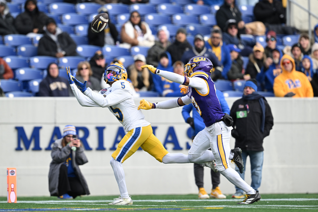 Pittsburgh wide receiver Raphael Williams Jr. (5) catches a pass and scores a touchdown as East Carolina defensive back Ayden Duncanson (13) covers during the first half of the Military Bowl NCAA college football game, Saturday, Dec. 27, 2025, in Annapolis, Md. (AP Photo/Gail Burton)