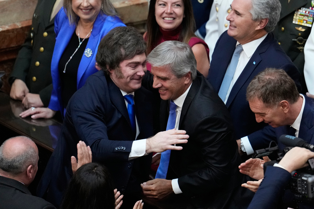 Argentina's President Javier Milei, left, greets Economy Minister Luis Caputo before delivering the annual State of the Nation address at Congress in Buenos Aires, Argentina, Sunday, March 1, 2026. (AP Photo/Gustavo Garello)