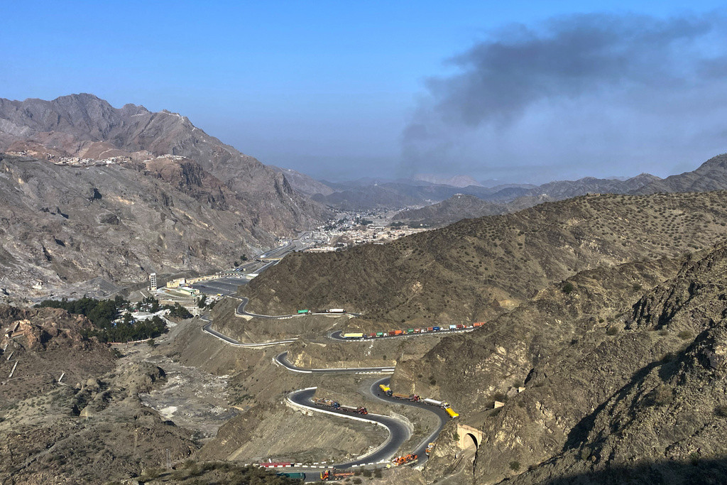 Smoke emits from Afghan side as trucks are parked along roadside following cross-border clashes between Pakistan and Afghan forces, at near Torkham border crossing point, Pakistan, Saturday, Feb. 28, 2026. (AP Photo/Maaz Awan)