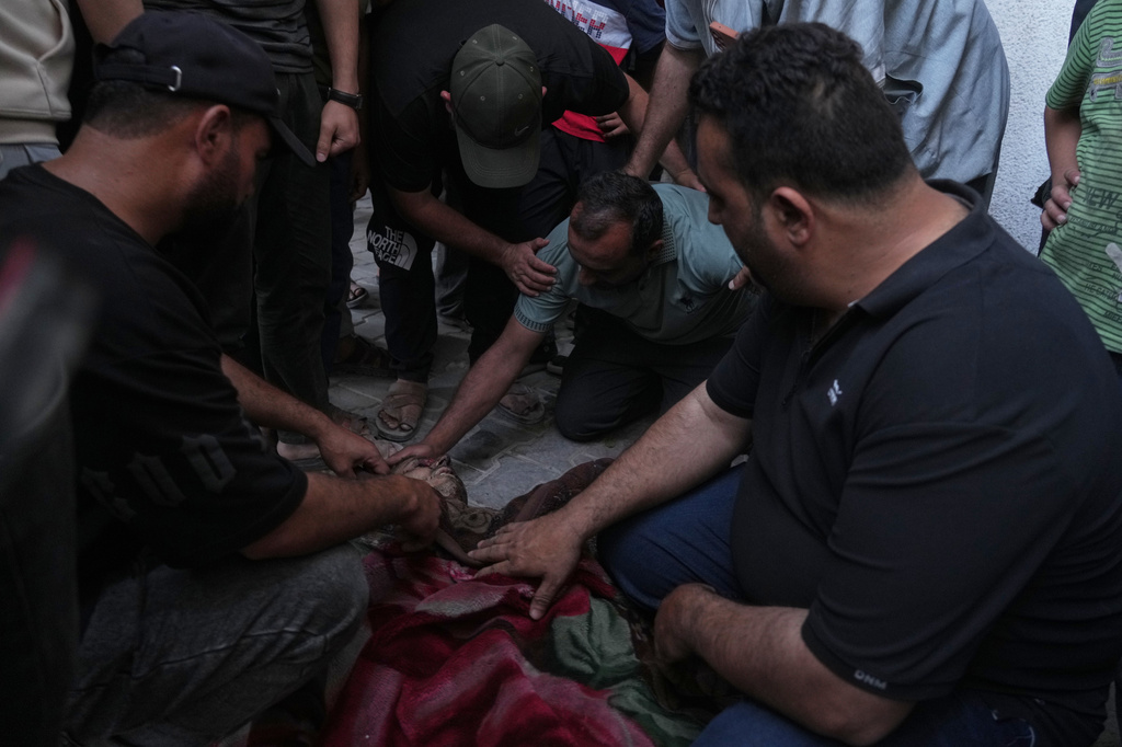 Residents gather by the body of a killed Palestinian man following an Israeli airstrike in the port of Gaza city, Sunday, May 31, 2026. , Gaza Strip, Monday, May 12, 2026. (AP Photo/Jehad Alshrafi)