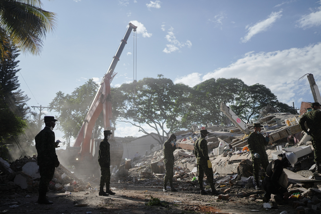 Soldiers clear debris three days after an earthquake struck Cali, Colombia, Thursday, Aug. 13, 2026. (AP Photo/Ivan Valencia)