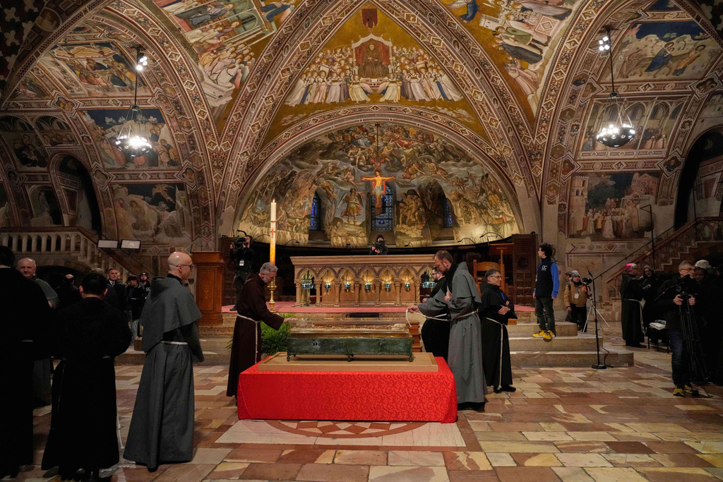 Friars pray before the remains of Francis of Assisi inside the Basilica of St. Francis of Assisi in Assisi, Italy, Saturday, Feb. 21, 2026, on the eve of a public exposition beginning Feb. 22 to mark the 800th anniversary of his death in 1226. (AP Photo/Gregorio Borgia)