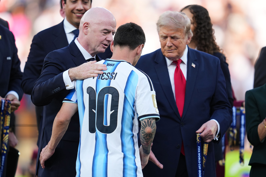 FIFA President Gianni Infantino, left, and President Donald J. Trump, right, shake hands with Argentina's Lionel Messi at as the present him his runner-up medal after the World Cup final soccer match between Spain and Argentina in East Rutherford, N.J., near New York, Sunday, July 19, 2026. (AP Photo/Abbie Parr)