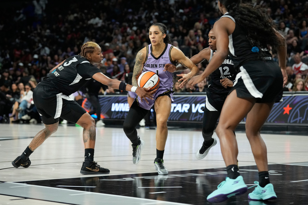 Golden State Valkyries forward Gabby Williams (1) drives against Las Vegas Aces guard Chelsea Gray (12) and Las Vegas Aces forward Nalyssa Smith (3) during the first half of a WNBA basketball game Sunday, June 21, 2026, in Las Vegas. (AP Photo/John Locher)