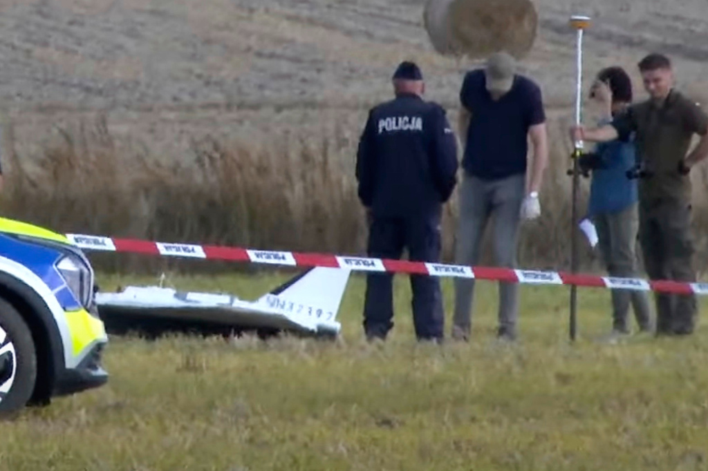 In this image made from video, Police and Military Police secure parts of a damaged object shot down by Polish authorities at a site in Wohyn, Poland, Wednesday, Sept. 10, 2025. (AP Photo/Rafal Niedzielski)