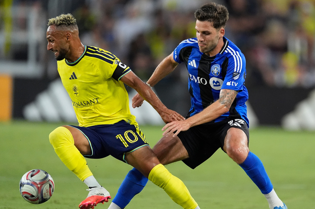 Nashville SC midfielder Hany Mukhtar (10) moves the ball past CF Montréal defender Luca Petrasso (13) during the first half of an MLS soccer match Wednesday, July 22, 2026, in Nashville, Tenn. (AP Photo/George Walker IV)
