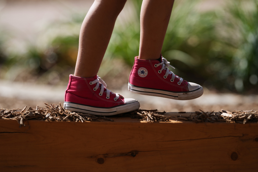 A Pre-K 4 SA student walks a beam on the playground, Oct. 9, 2025, in San Antonio. (AP Photo/Eric Gay)