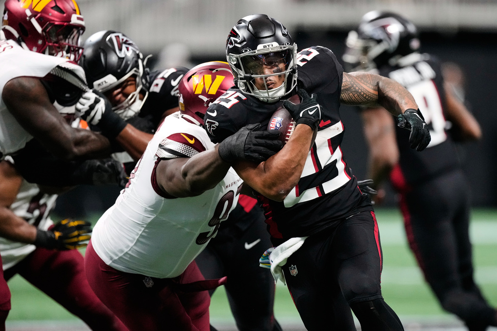 Atlanta Falcons running back Tyler Allgeier (25) runs the ball past Washington Commanders nose tackle Eddie Goldman, left, for a touchdown during the second half of an NFL football game, Sunday, Sept. 28, 2025, in Atlanta. (AP Photo/Brynn Anderson)