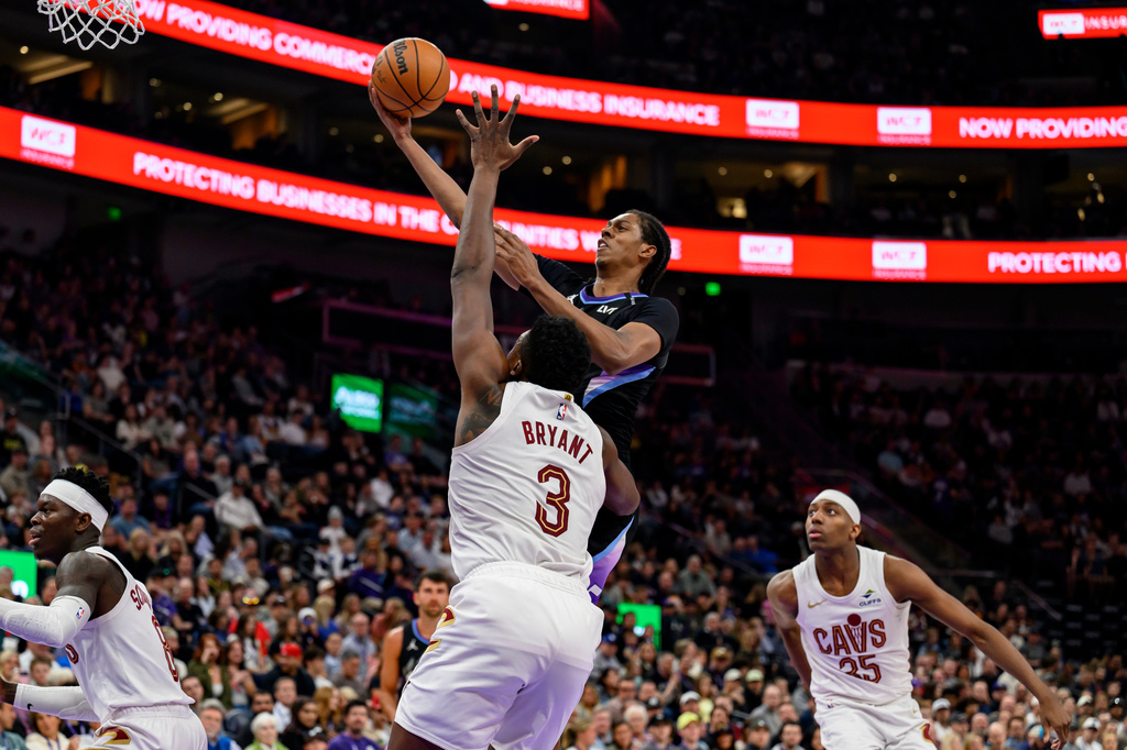 Utah Jazz forward Cody Williams, top center, goes to the basket for a layup over the defense of Cleveland Cavaliers center Thomas Bryant (3) during the first half of an NBA basketball game, Monday, March 30, 2026, in Salt Lake City. (AP Photo/Tyler Tate)