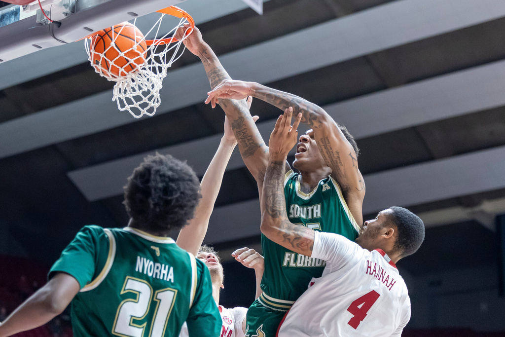 South Florida forward Izaiyah Nelson (35) puts back a rebound for over Alabama guard Davion Hannah (4) during the second half of an NCAA college basketball game, Wednesday, Dec. 17, 2025, in Tuscaloosa, Ala. (AP Photo/Vasha Hunt)