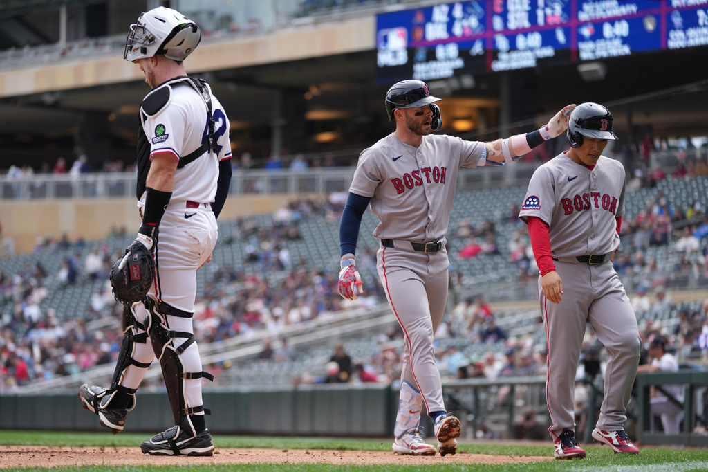 Boston Red Sox's Trevor Story, center, celebrates with Masataka Yoshida, right, after hitting a three-run home run during the third inning of a baseball game against the Minnesota Twins, Wednesday, April 15, 2026, in Minneapolis. (AP Photo/Abbie Parr)