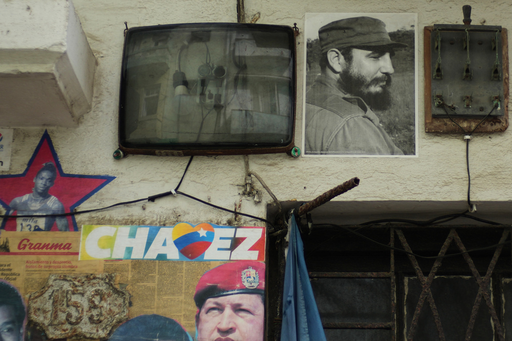 A picture of Cuba's late Fidel Castro and Venezuela's late Hugo Chavez hang outside a building next to electric wires during a blackout in Havana, Tuesday, March 17, 2026. (AP Photo/Ramon Espinosa)