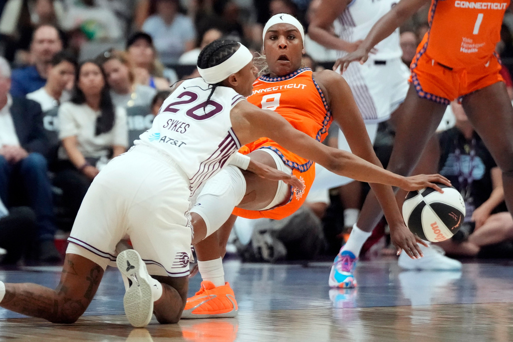 Toronto Tempo's Brittney Sykes (20) and Connecticut Sun's Aaliyah Edwards (8) battle for a loose ball during first half WNBA action in Toronto, Ontario, Wednesday, June 10, 2026. (Frank Gunn/The Canadian Press via AP)