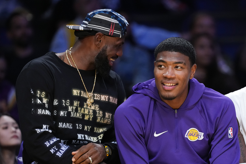Los Angeles Lakers' Lebron James, left, and Rui Hachimura share a light moment on the bench during the first half of a preseason NBA basketball game against the Sacramento Kings Friday, Oct. 17, 2025, in Los Angeles. (AP Photo/Jae C. Hong)
