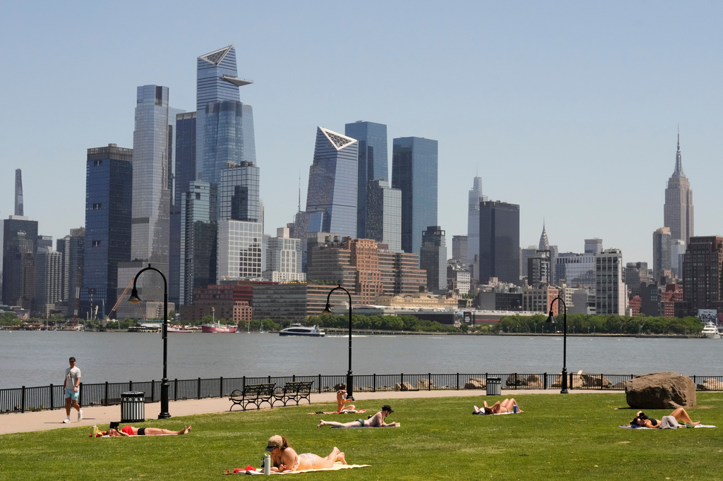 People lay out in the sun in front of the New York City skyline, in Hoboken, N.J., Wednesday, May 20, 2026. (AP Photo/Seth Wenig)