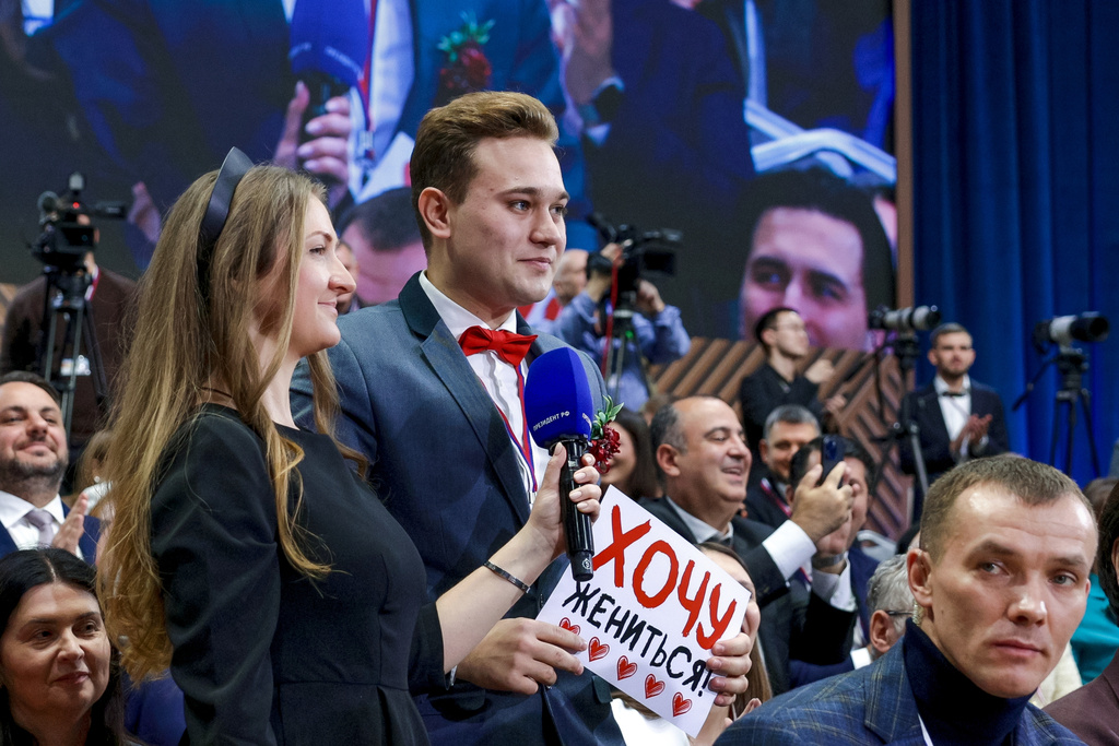 Kirill Bazhanov of Yekaterinburg's Channel 4, center, asks a question holding a sign saying he wanted to get married, during Russian President Vladimir Putin's annual news conference at Gostinny Dvor in Moscow, on Friday, Dec. 19, 2025. (Gavriil Grigorov, Sputnik, Kremlin Pool Photo via AP)