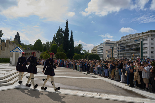 Tourists watch the changing of the guard at the Tomb of the Unknown Soldier in front of the Greek parliament, in Athens, Tuesday, Oct. 21, 2025, as lawmakers debate regulations to protect the monument, recently the focus of protests by relatives of victims of Greece's deadliest train crash. (AP Photo/Petros Giannakouris) Tourists watch the changing of the guard at the Tomb of the Unknown Soldier in front of the Greek parliament, in Athens, Tuesday, Oct. 21, 2025, as lawmakers debate regulations to protect the monument, recently the focus of protests by relatives of victims of Greece's deadliest train crash. (AP Photo/Petros Giannakouris)