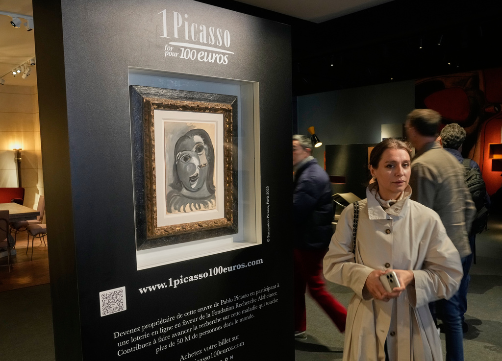 People walks past the Head of a Woman by Pablo Picasso, painted in 1941, in Paris, Friday, April 10, 2026, where the draw will be handled by auction house Christie's next week. (AP Photo/Michel Euler)