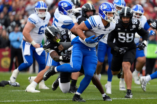 BYU running back LJ Martin pulls away from Iowa State defensive back Ta'Shawn James to score a touchdown during the first half of an NCAA college football game, Saturday, Oct. 25, 2025, in Ames, Iowa. (AP Photo/Matthew Putney) BYU running back LJ Martin pulls away from Iowa State defensive back Ta'Shawn James to score a touchdown during the first half of an NCAA college football game, Saturday, Oct. 25, 2025, in Ames, Iowa. (AP Photo/Matthew Putney)