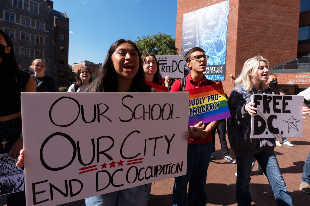 Georgetown University students, from left, Melanie Juan Cruz, Cosmo Salicone, and Kendra Kamrava, join a rally as they walk out of their classrooms in protest of the federal intervention in the District of Columbia, Tuesday, Sept. 9, 2025, in Washington. (AP Photo/Manuel Balce Ceneta)