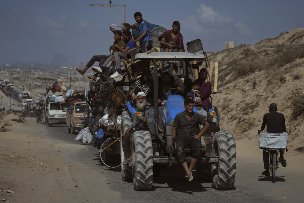 Displaced Palestinians fleeing northern Gaza carry their belongings along the coastal road toward southern Gaza, Tuesday, Sept. 9, 2025, after the Israeli army issued evacuation orders from Gaza City. (AP Photo/Jehad Alshrafi)