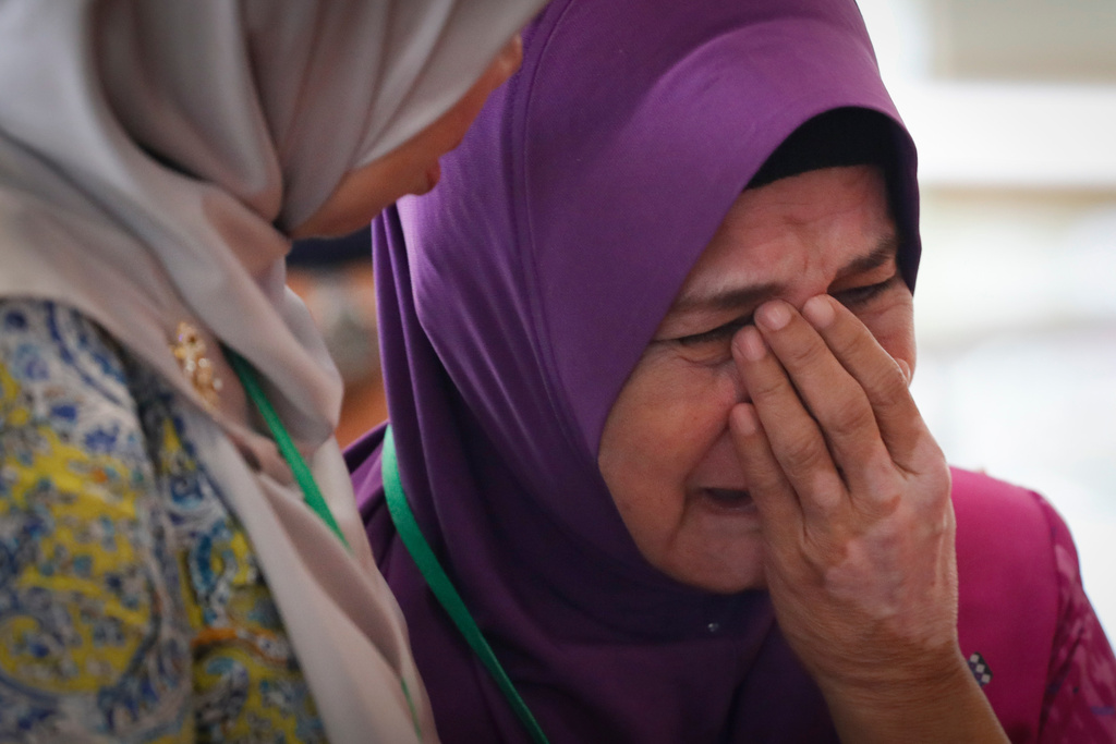 FILE -Sarah Nor, the mother of Norliakmar Hamid, a passenger on missing Malaysia Airlines flight MH370, cries after she attended a briefing on the final investigation report on missing flight MH370 in Putrajaya, July 30, 2018.(AP Photo/Vincent Thian, File)