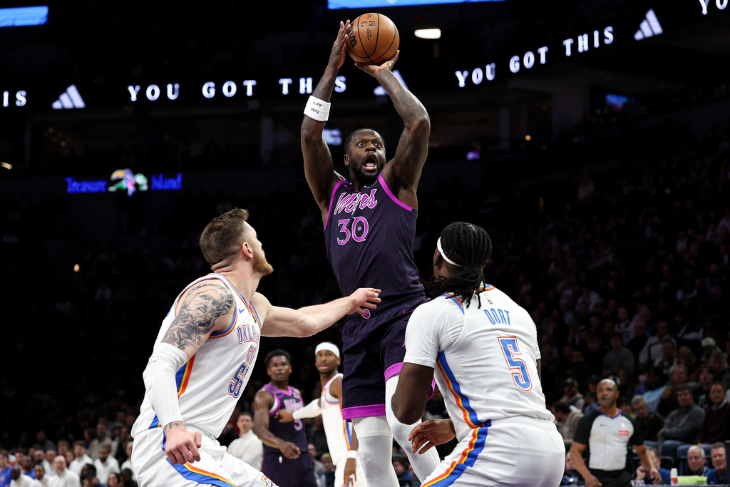 Minnesota Timberwolves forward Julius Randle (30) shoots as Oklahoma City Thunder center Isaiah Hartenstein, left, and guard Luguentz Dort (5) defend during the first half of an NBA basketball game Friday, Dec. 19, 2025, in Minneapolis. (AP Photo/Matt Krohn)