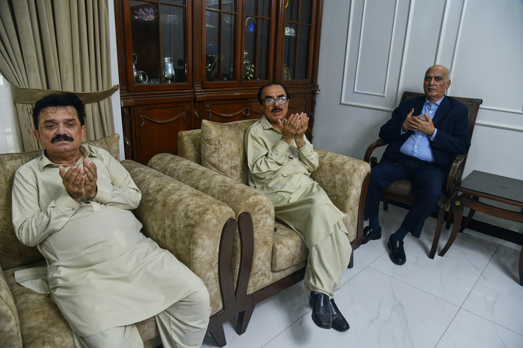 Ghulam Nabi Bahrani, left, father-in-law of missing cargo plane crew First Officer Faisal Jatoi, with others pray for Jatoi at his home in Karachi, Pakistan, Wednesday, July 8, 2026. (AP Photo/Ali Raza)