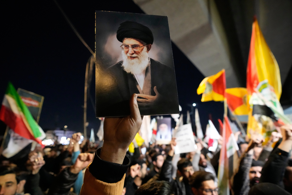 A protester holds a portrait of Iran's Supreme Leader Ayatollah Ali Khamenei during a protest against U.S. and Israeli attacks on multiple cities across Iran at a bridge leading to the fortified Green Zone where the U.S. embassy is located in Baghdad, Iraq, Saturday, Feb. 28, 2026. (AP Photo/Hadi Mizban)
