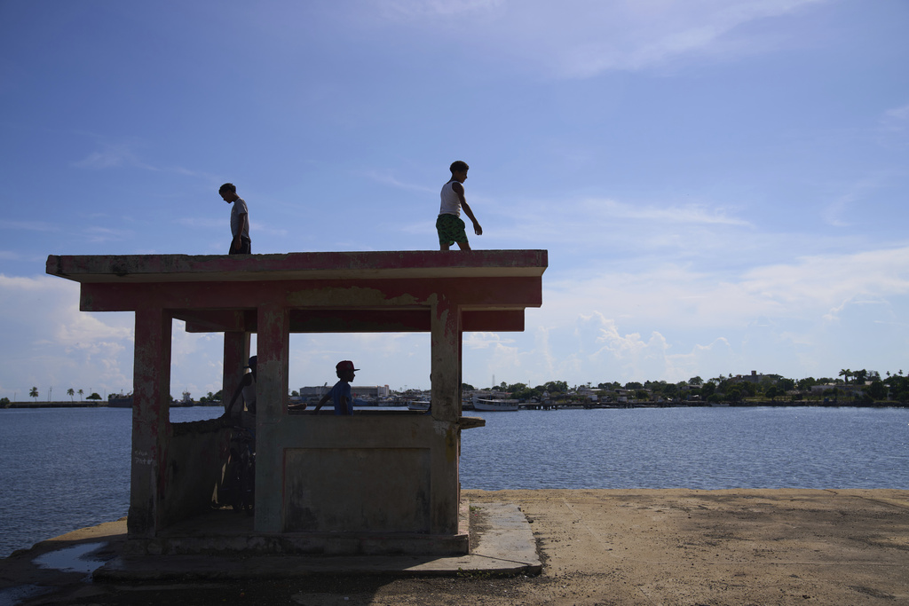 Youth stand at an unused security booth at the port in Güiria, on Venezuela's Paria Peninsula, Saturday, Sept. 13, 2025. (AP Photo/Ariana Cubillos)