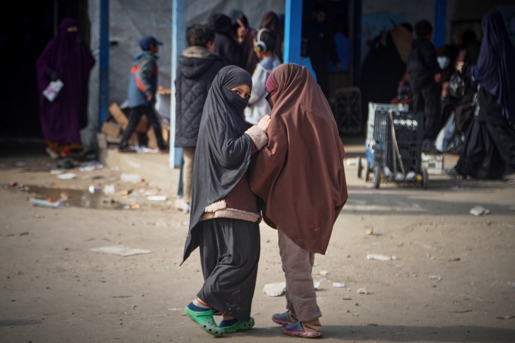 Two girls stand at Roj camp, one of the detention facilities holding thousands of Islamic State group members and their families, in the al-Malikiyah area of northeastern Syria, Thursday, Jan. 29, 2026. (AP Photo/Baderkhan Ahmad)