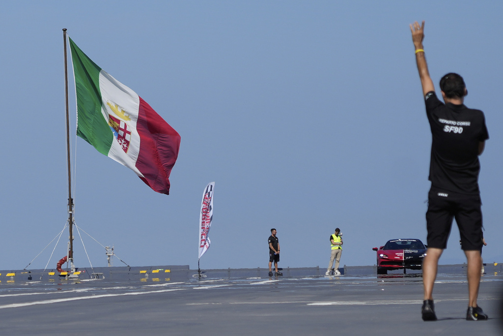 Italian driver Fabio Barone attempts to break his own speed record on a ship, at the wheel of a Ferrari SF 90, on the flight deck of the Italian Navy aircraft carrier Nave Trieste, docked at the port of Civitavecchia, Thursday, Sept. 18, 2025. (AP Photo/Gregorio Borgia)